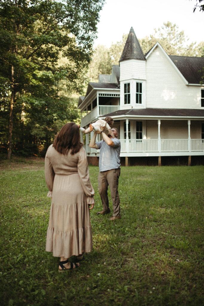 a dad plays with his daughter while mom watches on with wonder