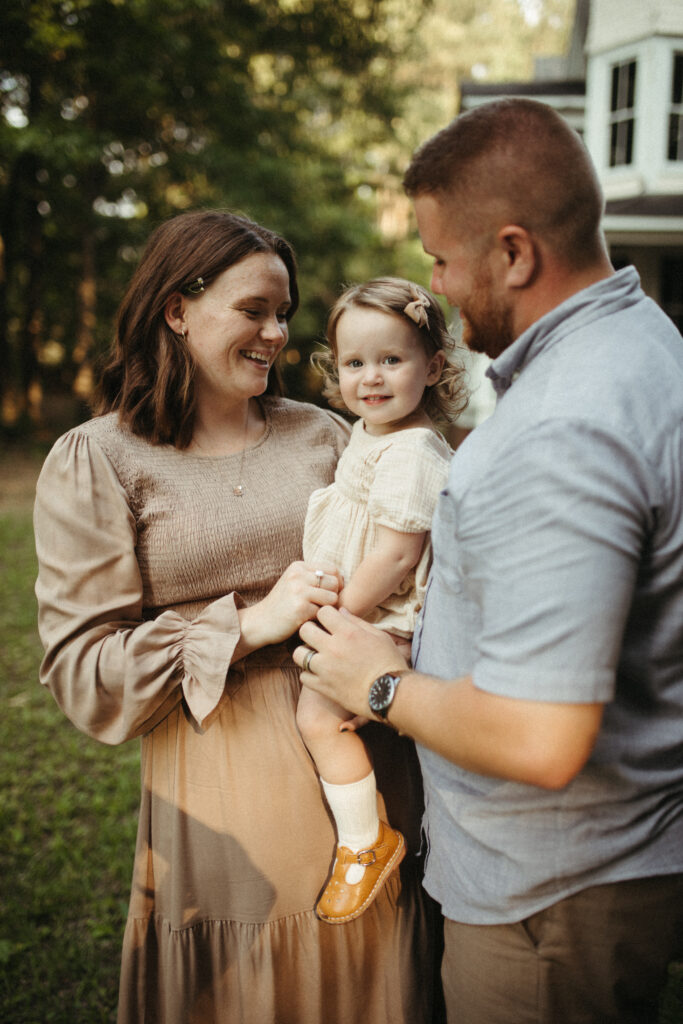 a family laughing after the daughter wanted mom to wear the flower she got for her