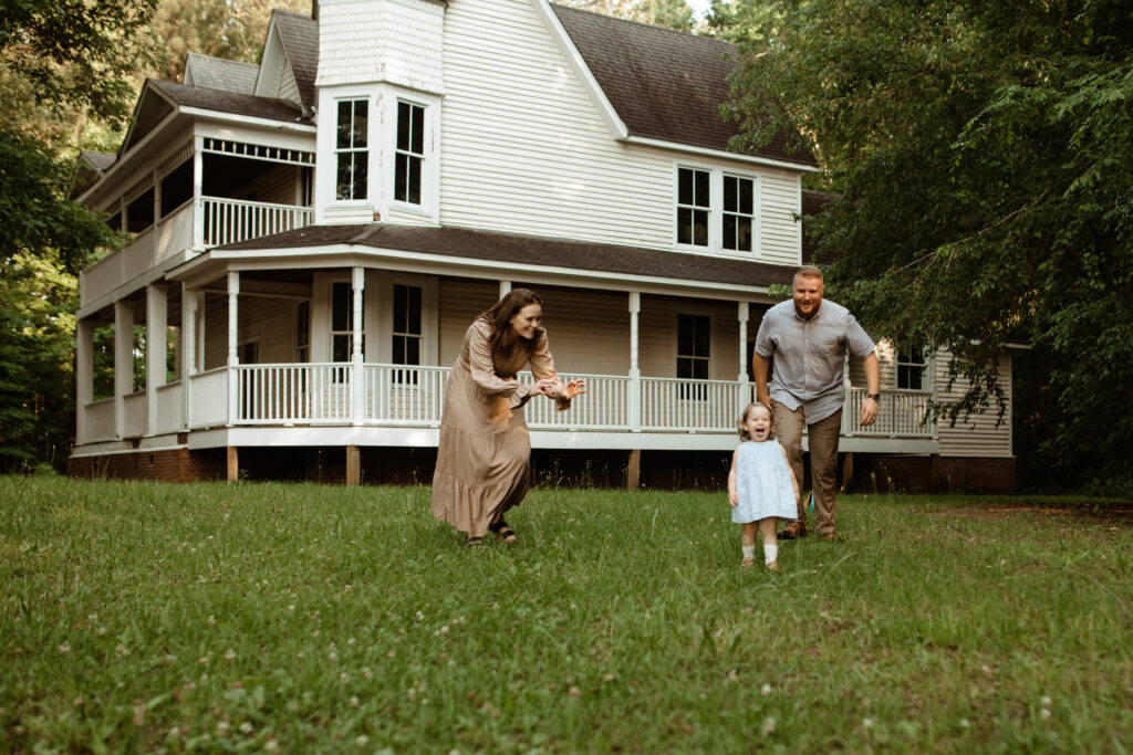 a family plays chase with their daughter full of laughter