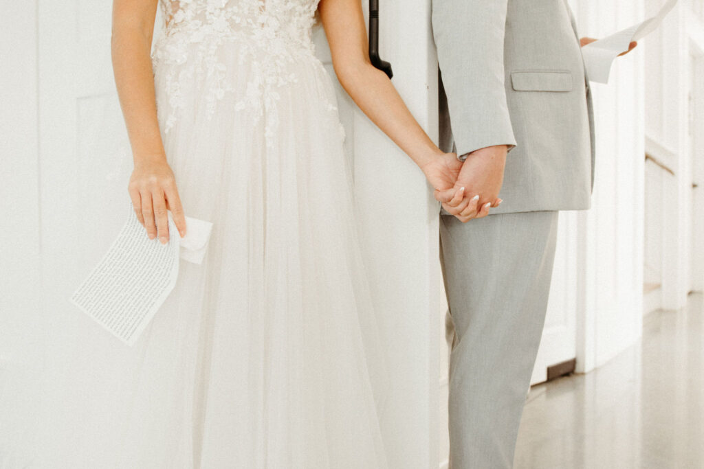 bride and groom holding hands during a first touch